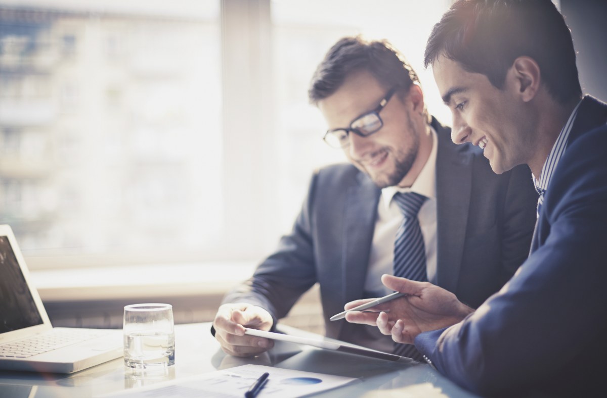 Two business professionals reviewing a document on a tablet